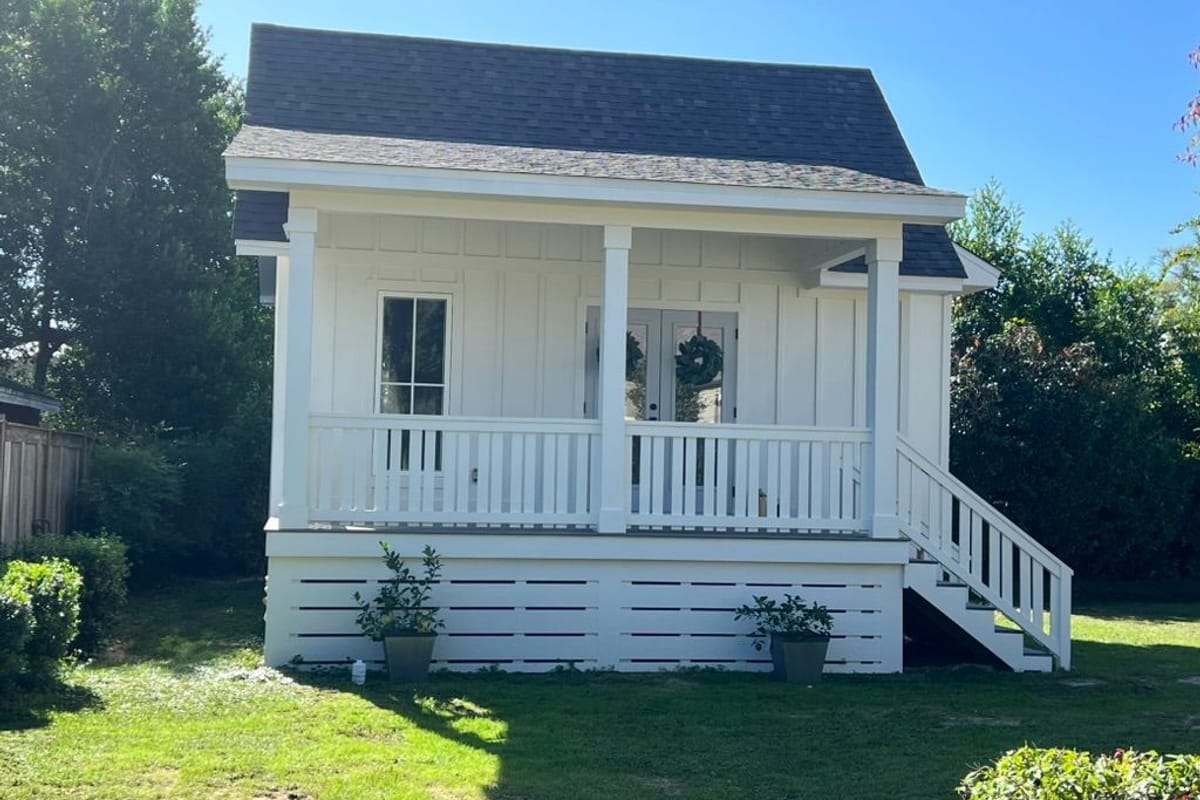 White cottage with a painted front porch and new shutters