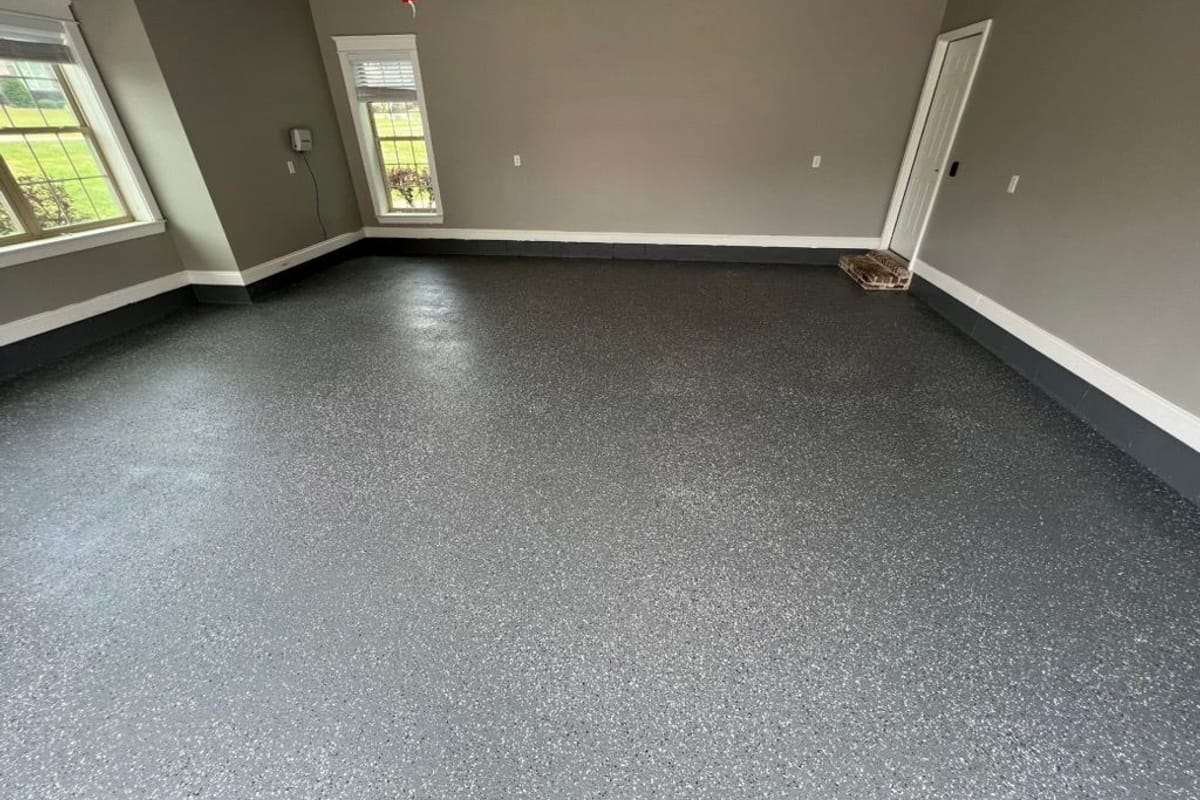 Garage floor coated in a grey flake epoxy finish with painted walls