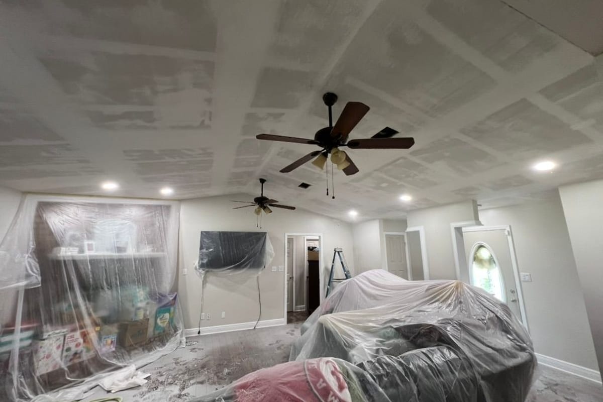 Living room masked and covered in plastic before the ceiling and walls are sprayed