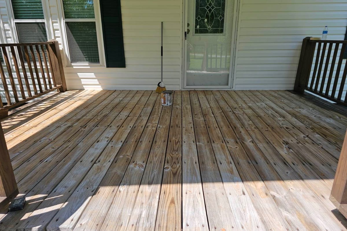 Wood porch deck washed clean before staining, boards drying in the sun